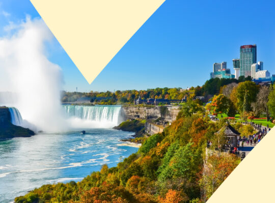 A picture of a city with a waterfall and a large city in the background.