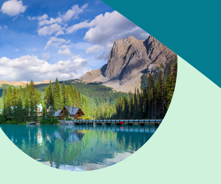 A picture of a lake and mountains with a forest in the background.