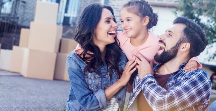 A couple and a child are smiling together.