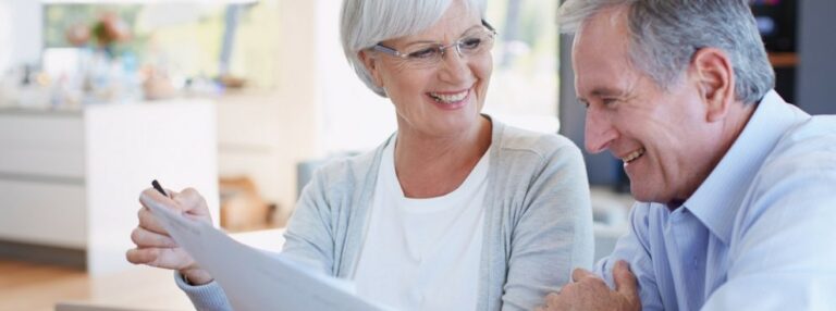 A couple is smiling and looking at a paper