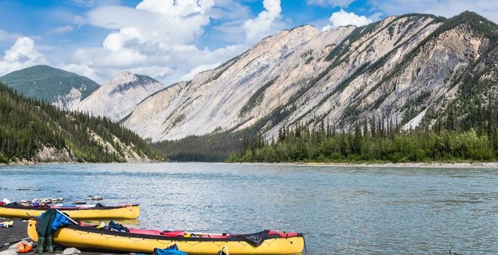 A couple of boats floating on top of a river.