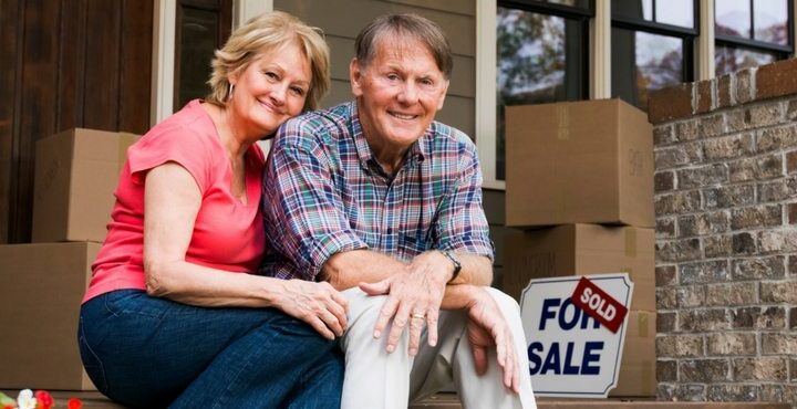 A couple sitting with a couple of boxes for sale.