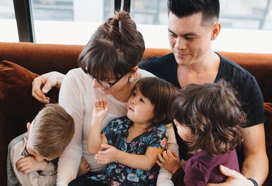 A family sitting together on a couch in a living room.