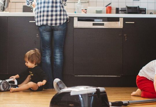 A person and a child are in the kitchen.