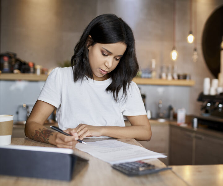 A person sitting at a table with a notebook and pen.