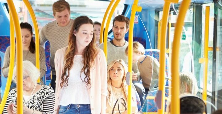 A group of people standing on a bus.