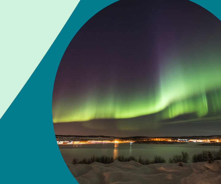 A group of greenish lights shining on a snowy hill.