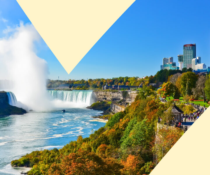 A picture of a city with a waterfall and a large city in the background.