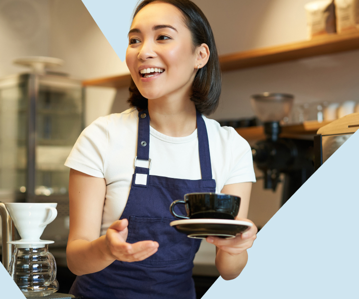 A person is holding a cup and a saucer.