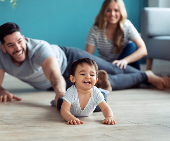 A person and a baby sitting on the floor.