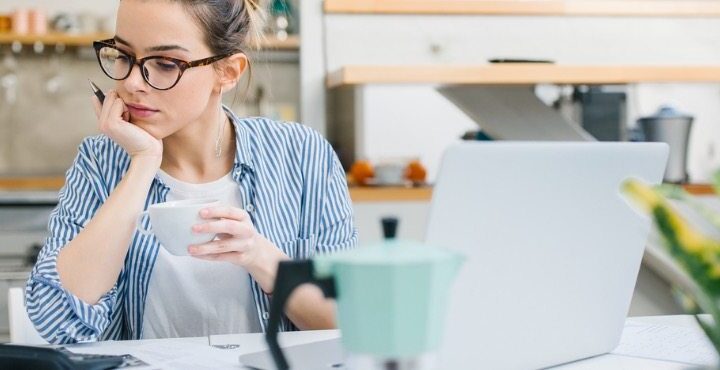 A person is holding a cup and a pen.