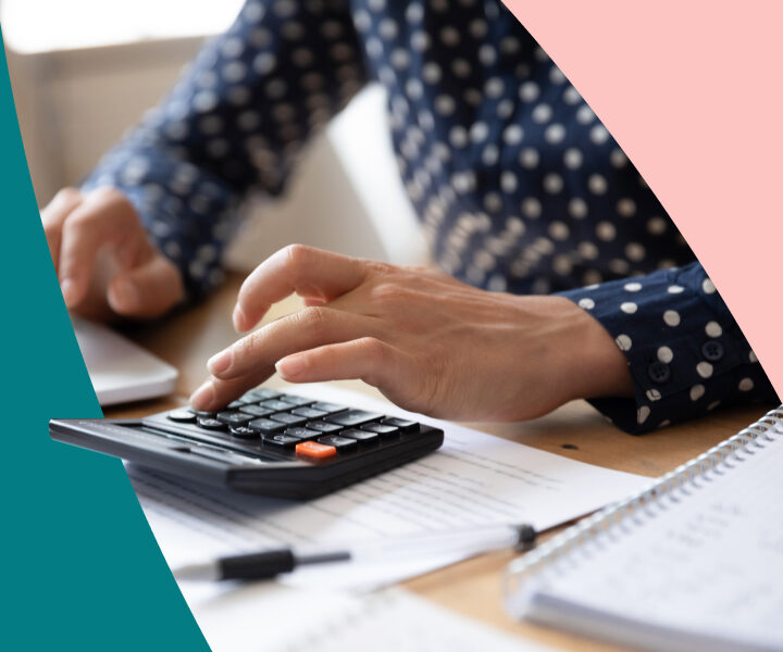 A person holding a laptop computer with a calculator on it.