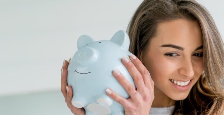 A person holding a piggy bank in her hand.