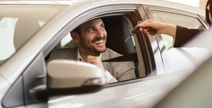 A person and person in a car smiling and talking.