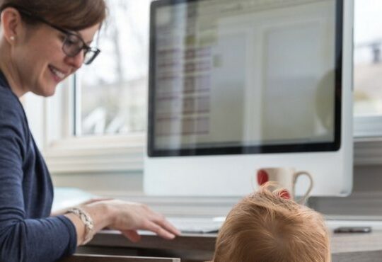 A person sitting at a desk with a child.