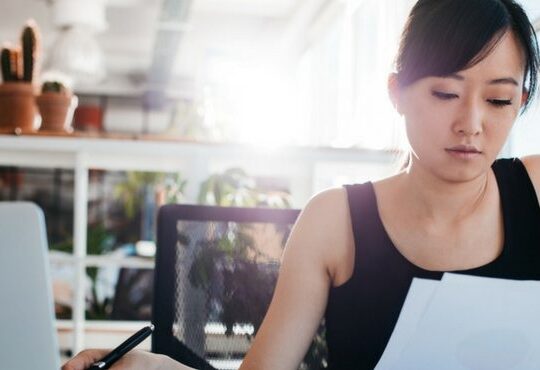 A person sitting at a desk with a laptop.