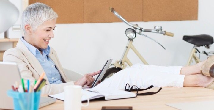 A person sitting at a desk with a tablet.