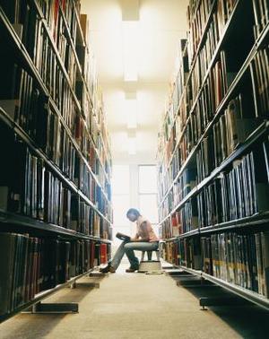 A person is sitting in a library.