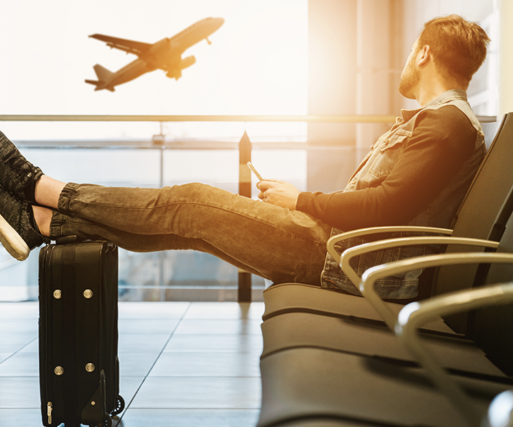 A person is sitting on a bench with luggage.