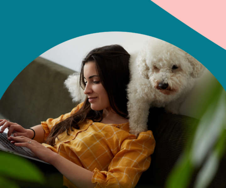 A person sitting on a couch with a dog.