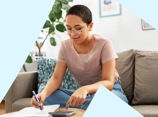 A person sitting on a couch with a pen and a paper.