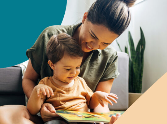 A woman is holding a book and a child.