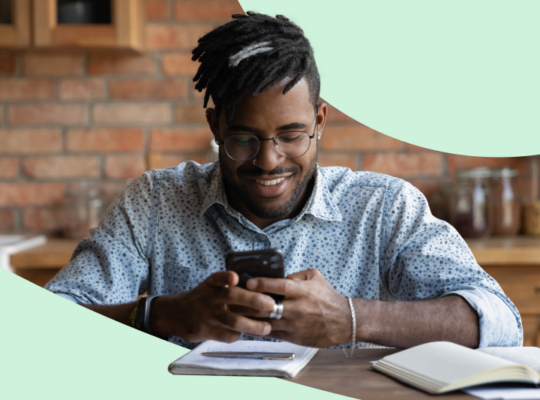 A person sitting in a chair holding a smart phone.
