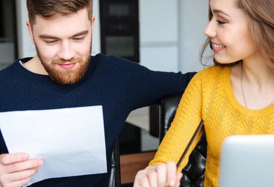 A person and a person are looking at a piece of paper.