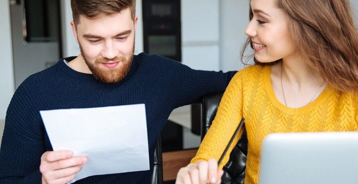 A person and a person are looking at a piece of paper.