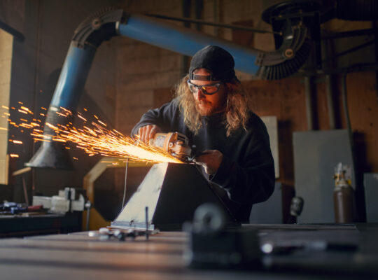 A person is working on metallic machine.