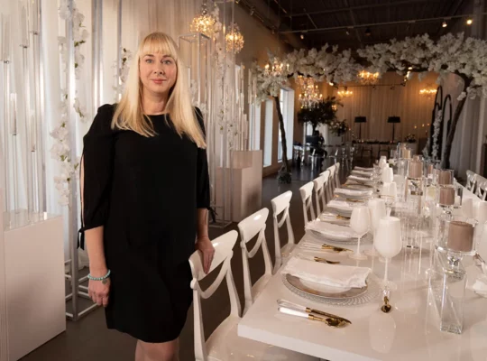 A women standing next to chair.