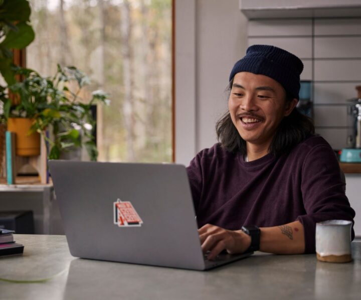 A person sitting at a desk with a laptop computer.