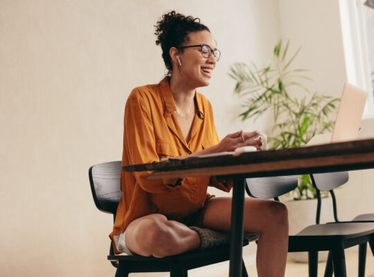 A person sitting at a table with a laptop.