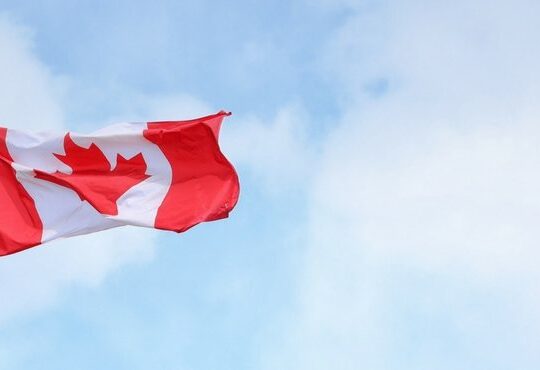 A Canadian flag flying in the air.