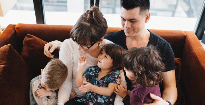 A family sitting together on a couch in a living room.