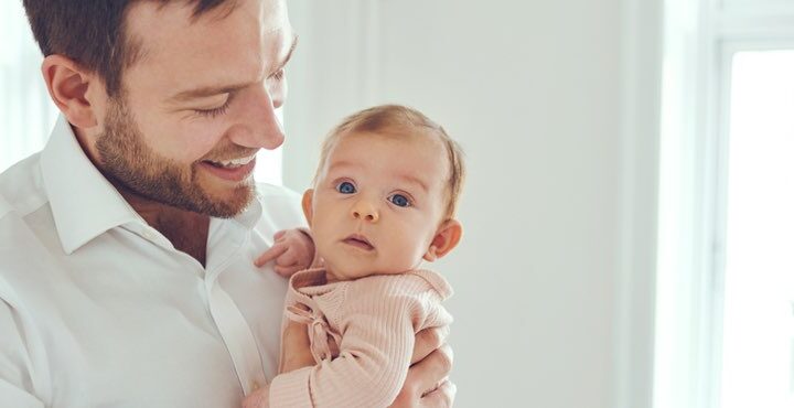 A person holding a baby in his arms.