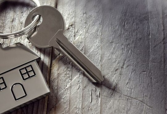 A picture of a key with a kitchen of house.