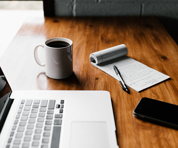 A table having a laptop and a cup of coffee.