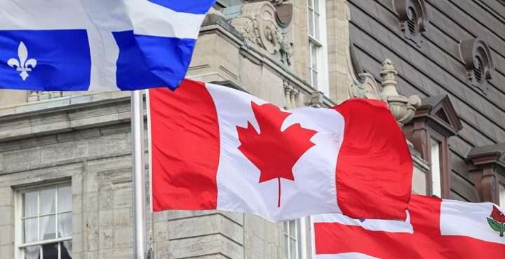 A Canadian flag flying in front of a building.