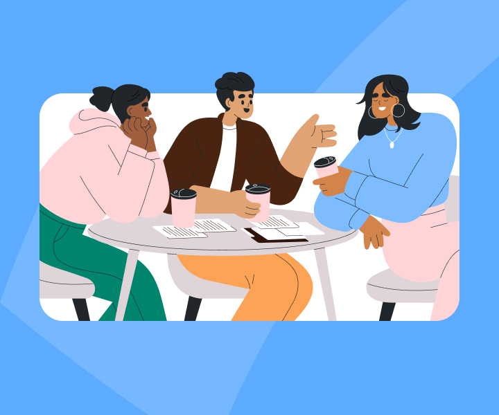Three people sitting and chatting holding coffee with documents on the table