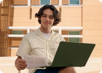 TurboTax customer Kaveh smiles as he looks down at his tax form.