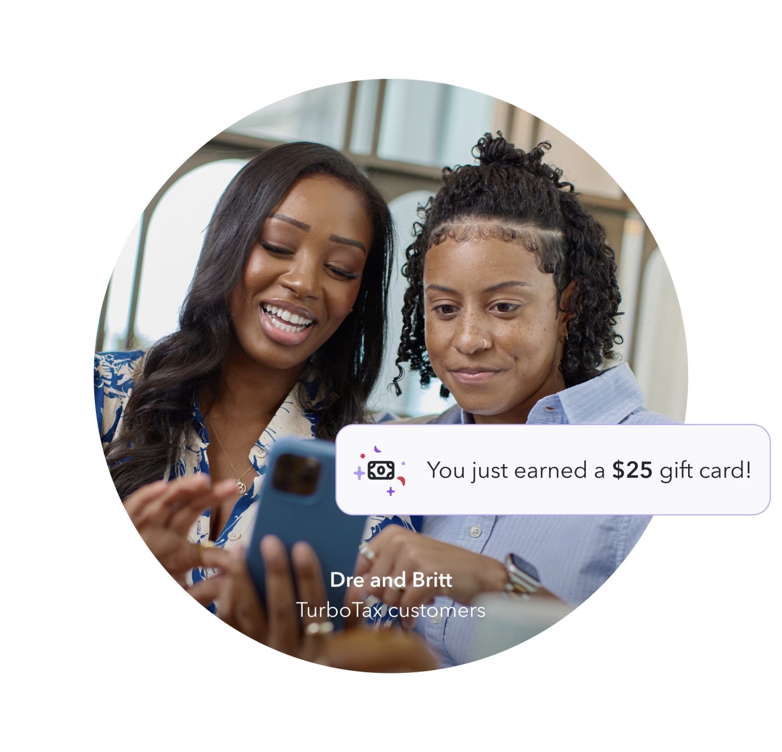 Two friends looking at phone while smiling because they used TurboTax's referral program to earn a gift card.