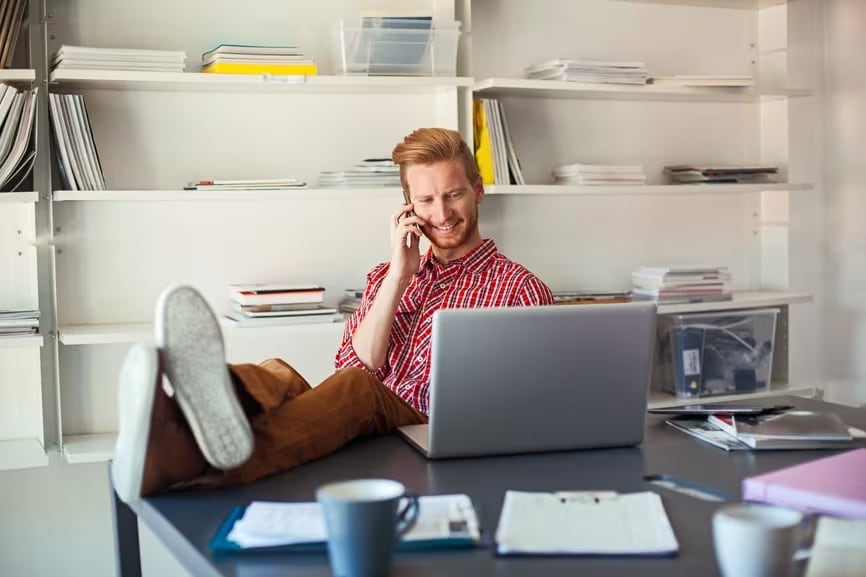 A person sitting in a chair with a laptop computer.