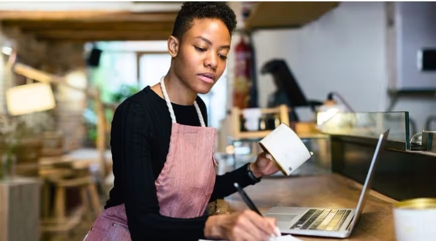 A person is working on a laptop in a kitchen.