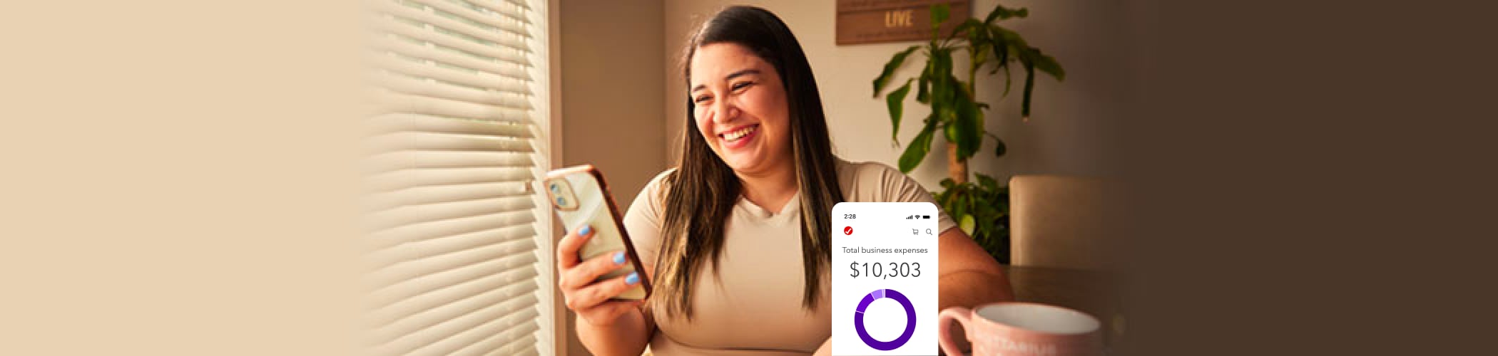 TurboTax customer Vanessa smiles as she looks down at her phone in her hands.