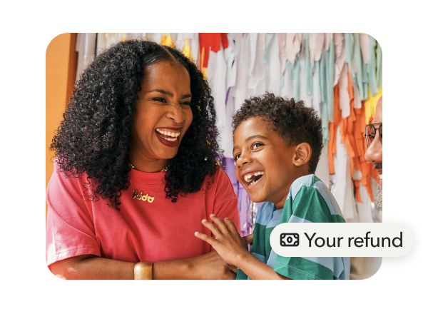 Mother and young son laughing while playing with "Bills paid" message displayed