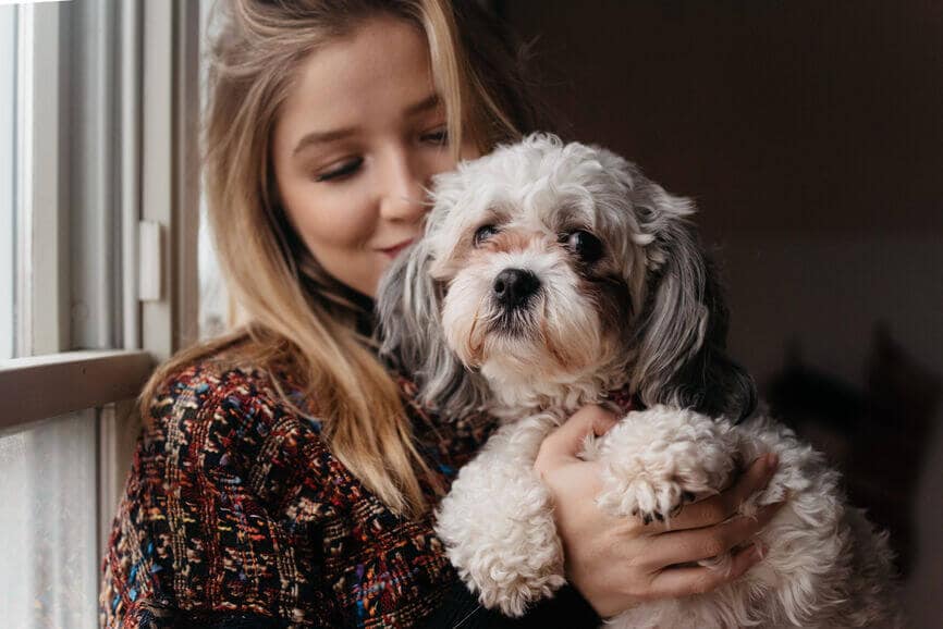 a woman with her small dog at home