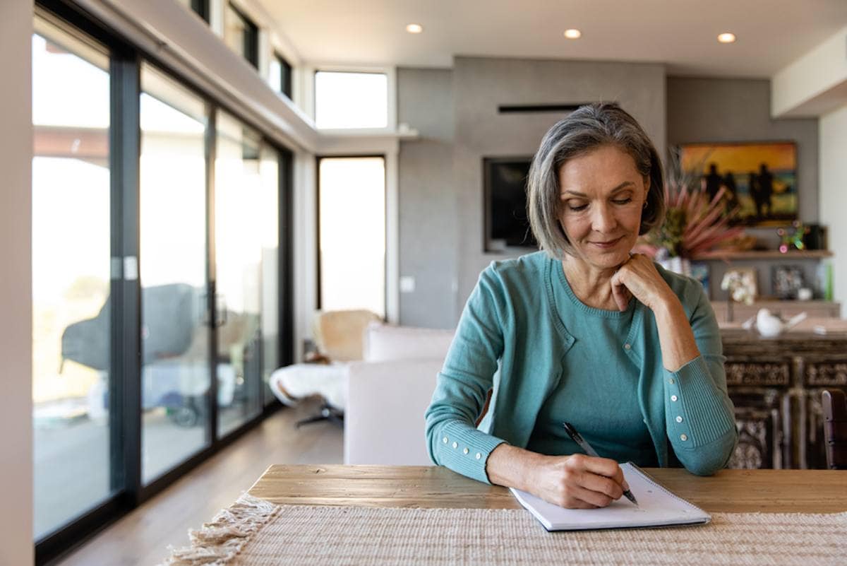 Person looking over paperwork at a kitchen table