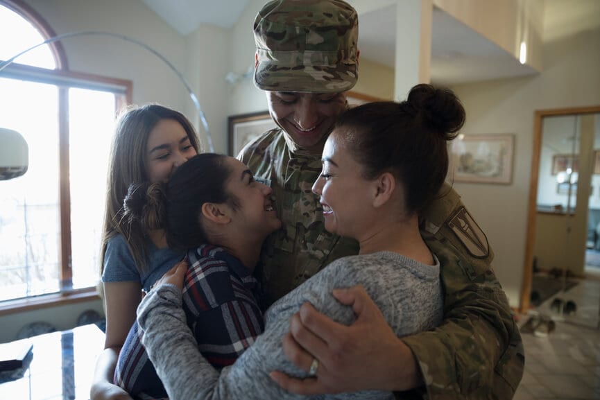 American military member hugging his family.