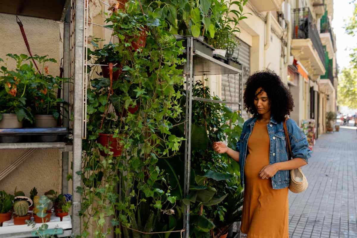 Pregnant woman examines plant at a florist shop